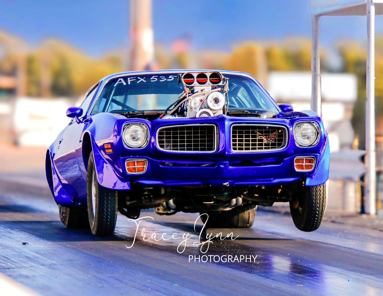 Blue drag car launching at the track
